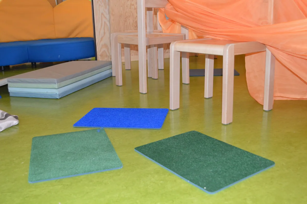 Drei kleine Teppiche auf dem Boden.